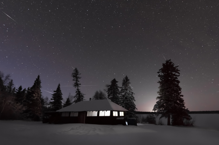 nocne niebo nad zaśnieżonym domem