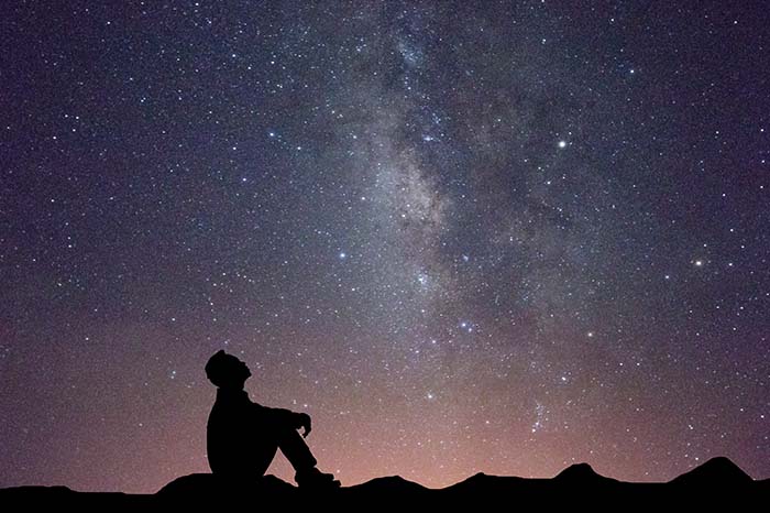 osoba obserwuje w nocy gwiazdy